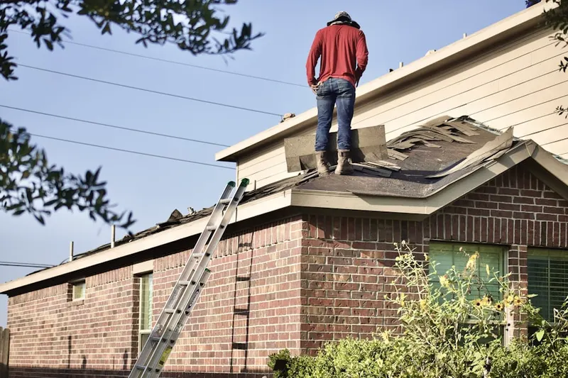 Professional roofer working on a residential roof in Heaton Park